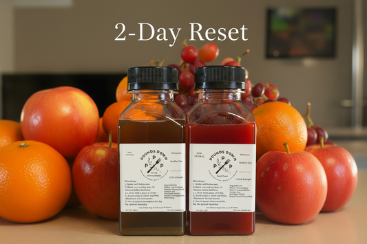 Pounds Down 2-Day Reset Cleanse bundle with two 8 oz Extra Strength herbal detox drinks in berry pomegranate and fruit punch flavors surrounded by fresh fruit
